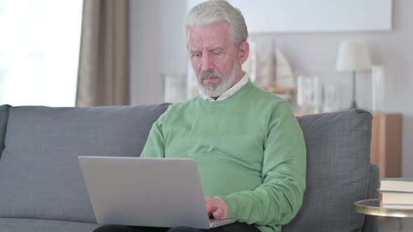 Old Man with Laptop Showing No Sign with Finger