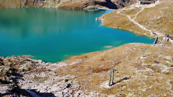 Aerial View Of Weisssee Lake And Reservoir With Ski Lift Tower On A Sunny Day In Salzburg, Austria.