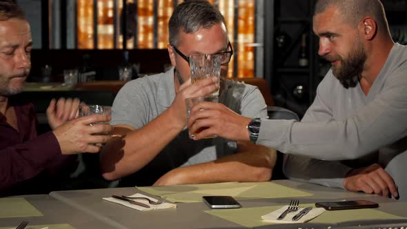 Two Mature Men Supporting Their Upset Friend While Drinking at the Bar