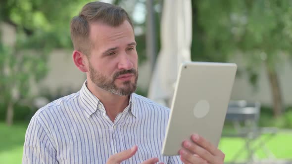 Outdoor Portrait of Middle Aged Man Talking on Video Call on Tablet