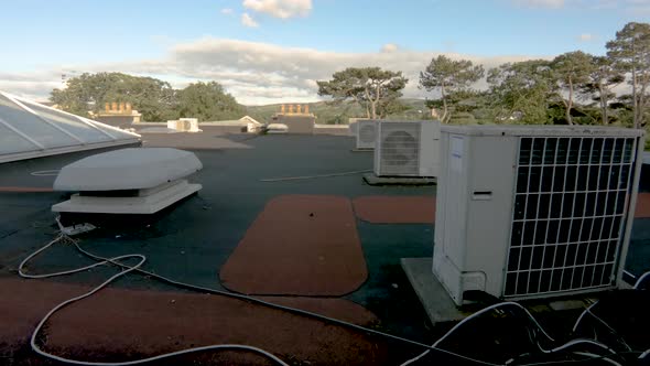 Air Compressor on Roof of Building with Blue Sky and Clouds Time Lapse