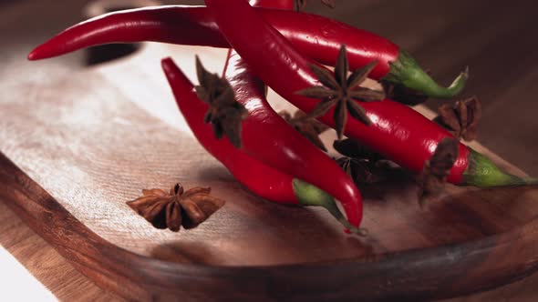 Red Chilli Pepper and Anise Falling Down on Wood
