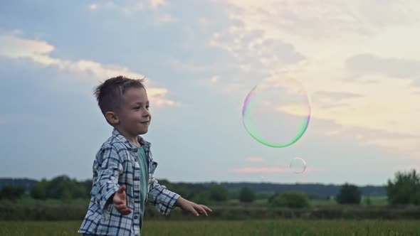 Slow Motion Video of a Boy Bursting Soap Bubbles