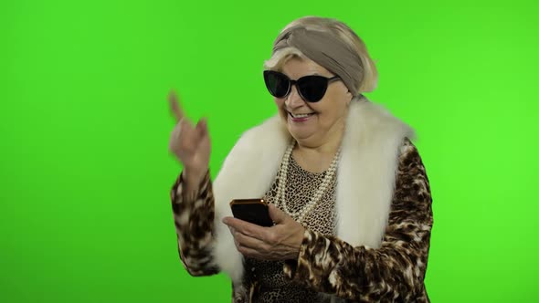 Caucasian Grandmother Woman Using Smartphone, Pointing at Something with Hand