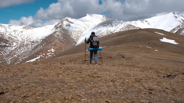 Woman Hiker with Backpack Traveling in Mountains