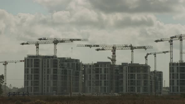 Large construction site with many cranes working over buildings