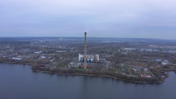 Aerial view of the Industrial Plant with Smoking Pipes near the City. 