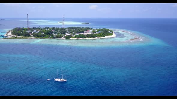 Aerial panorama of relaxing tourist beach trip by blue lagoon with white sandy background of adventu