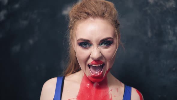 Playful Ad Predatory Young Woman Grins Her Teeth with Red Paint on Her Neck