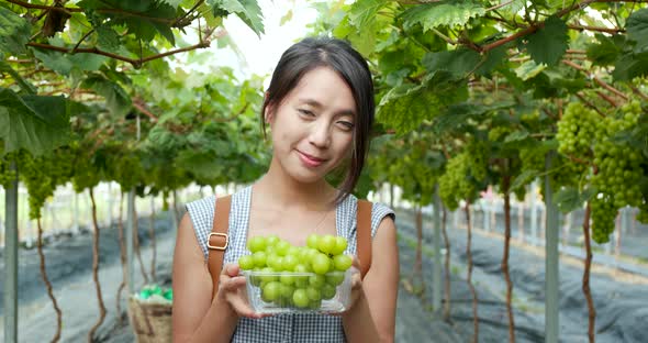 Woman holding green grape