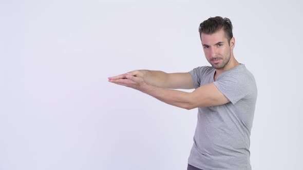 Young Happy Hispanic Man Snapping Fingers and Showing Something