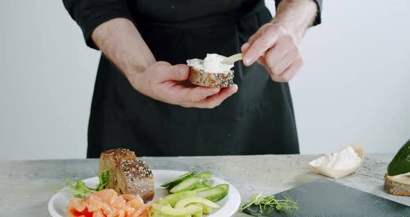 the Chef Spreads Bread Cream Cheese on Slice of Bread. Bread and Cheese Toast. Close Up. Slow Motion