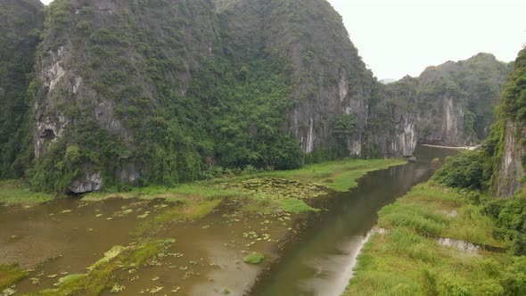 Aerial Shot of Beautiful Limestone Mountains with Passes Carved By a River in Ninh Binh Region a