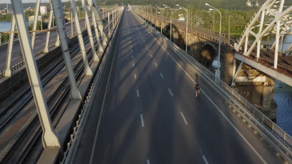 Aerial drone view of cyclist riding over the bridge