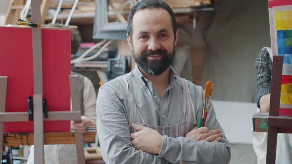 Portrait of Art Teacher Adult Man Smiling in Class While Students Painting in Background