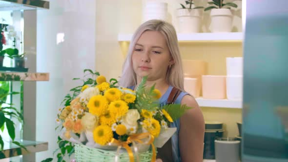 Blonde Florist Carries Yellow Flowers Bouquet in Basket