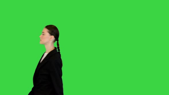 Young Woman Walking with Documents Wearing Office Suit on a Green Screen Chroma Key