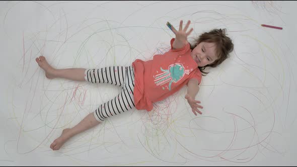 Little Girl Dabbles on Camera on Painted Floor