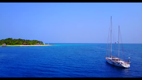 Aerial flying over scenery of relaxing seashore beach holiday by blue ocean with white sand backgrou