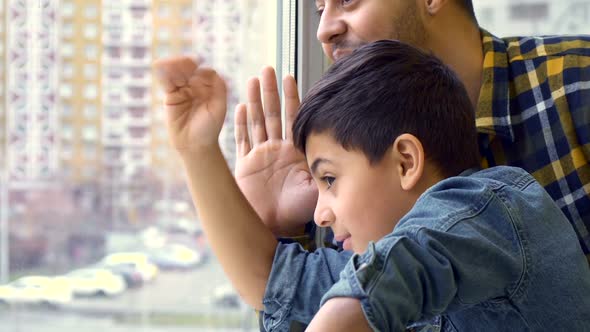 Boy and His Father Wave Out the Window