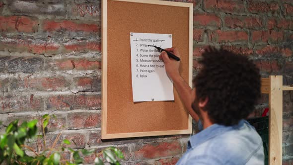 Man Crosses Out Accomplished Todo List Points in Room