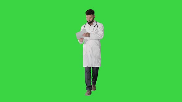 Doctor Reading Medical Report of Patient While Walking on a Green Screen, Chroma Key