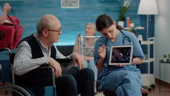 Patient with Disability Looking at Virus Animation on Digital Tablet