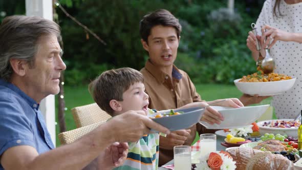 Family eating outside together in summer