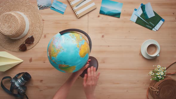 Female Hands Rotating Globe