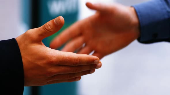 Two male commuters shaking hands