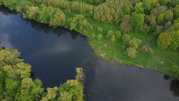 View of the river from above. Flight over water and forest trees from a height