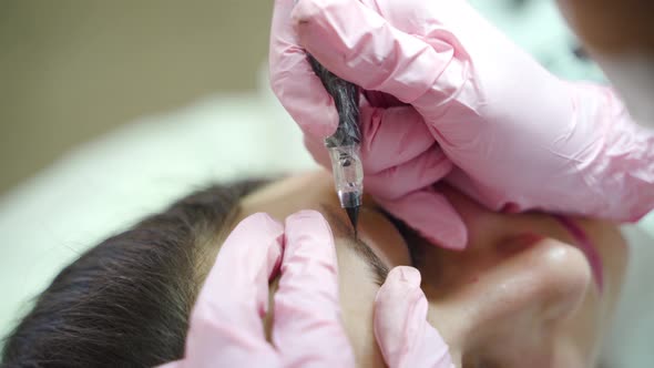 Cosmetologist is Making Eyebrow Staining with a Professional Needle for Permanent Eyebrow Makeup