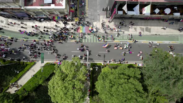 aerial drone shot of a person waving the gay pride flag in pride parade in mexico city