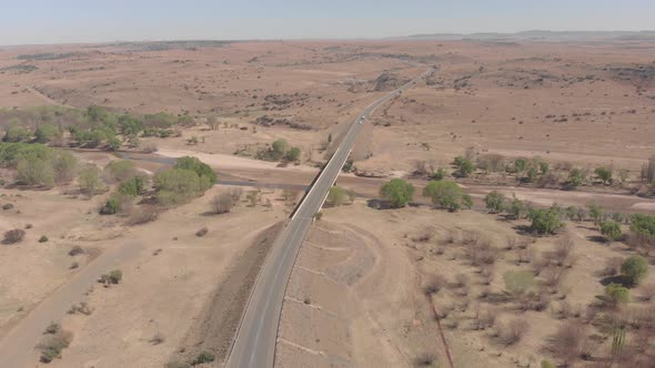 aerial shot circling a bridge covering a dry river