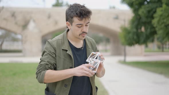 Close View of a Male Magician Showing Magic Tricks with Cards with the View of Bridge in the