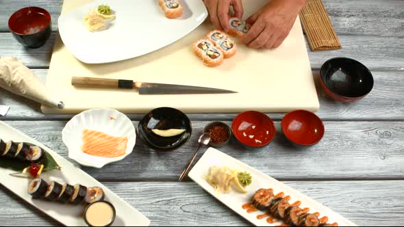 Hands Put Sushi on Plate.