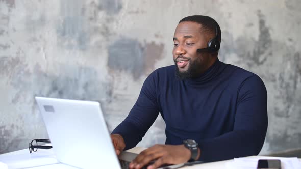 AfricanAmerican Male Employee Using Laptop for Video Call Indoor