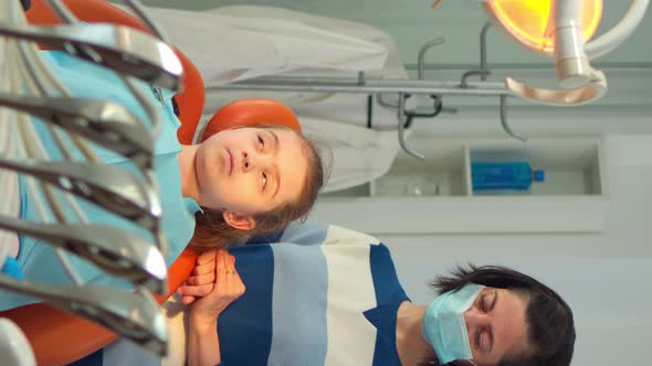 Vertical Video Orthodontist Lighting the Lamp Until Examining Kid