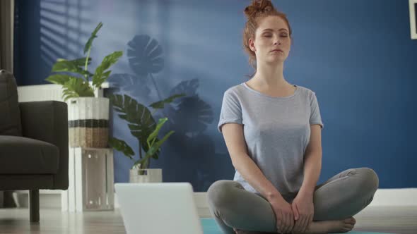 Video of woman meditating at home on exercise mat