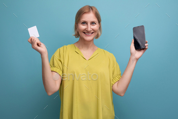 blond 50s woman makes a purchase online paying with her money card