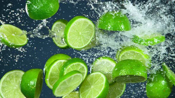 Super Slow Motion Shot of Flying Fresh Lime Slices and Water Side Splash at 1000Fps.