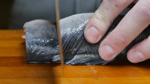 the Hands of the Chef Cut the Fish Into Steaks with a Large Meat Knife