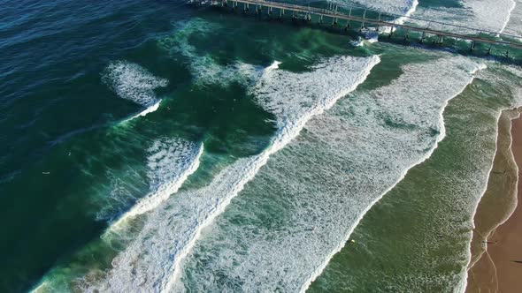 Descending down over waves ,Gold Coast dog beach and sand pumping jetty at sunset
