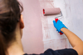 Young woman painting a wall with a paint roller - PhotoDune Item for Sale