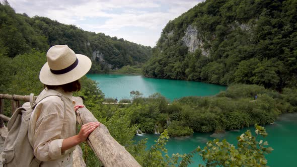 Attractive hiker looking at the turquoise Plitvice Lakes