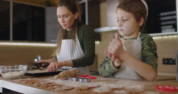 Young Family Mother and Son Making Homemade Cookies at Kitchen Table Working with Dough Smiling