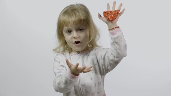 Kid Playing with Hand Made Toy Slime. Child Having Fun Making Red Slime