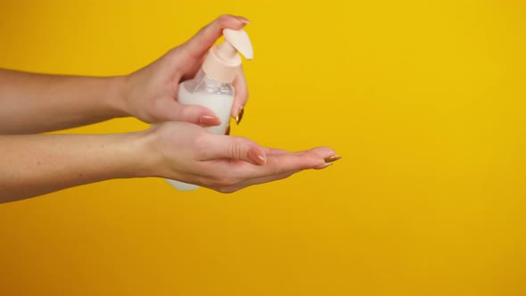 Washing Female Hands on Yellow Background Using Liquid Soap or Foam