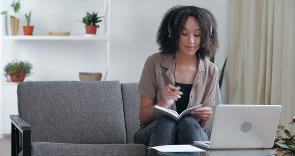 African Student Studying at Home Remotely in Quarantine Sitting on Couch with Laptop, Speaking on