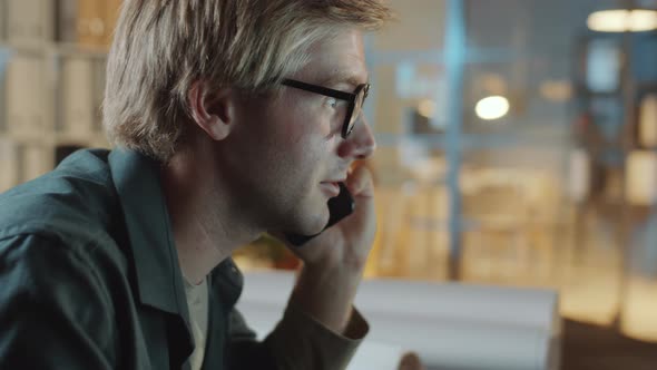 Businessman Speaking on Phone and Talking Notes in Night Office